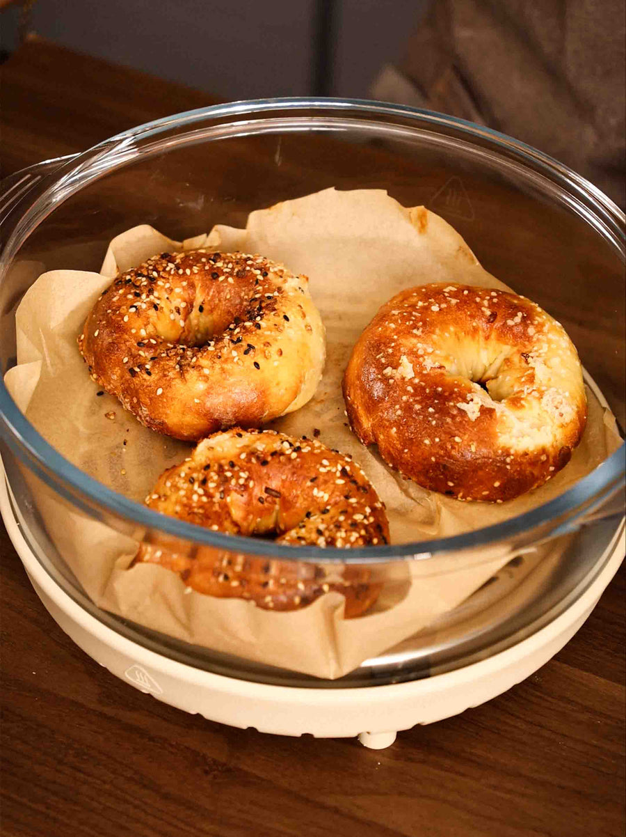 A batch of freshly baked Protein Bagels sitting in the Air Crisper Glass Pot Container.
