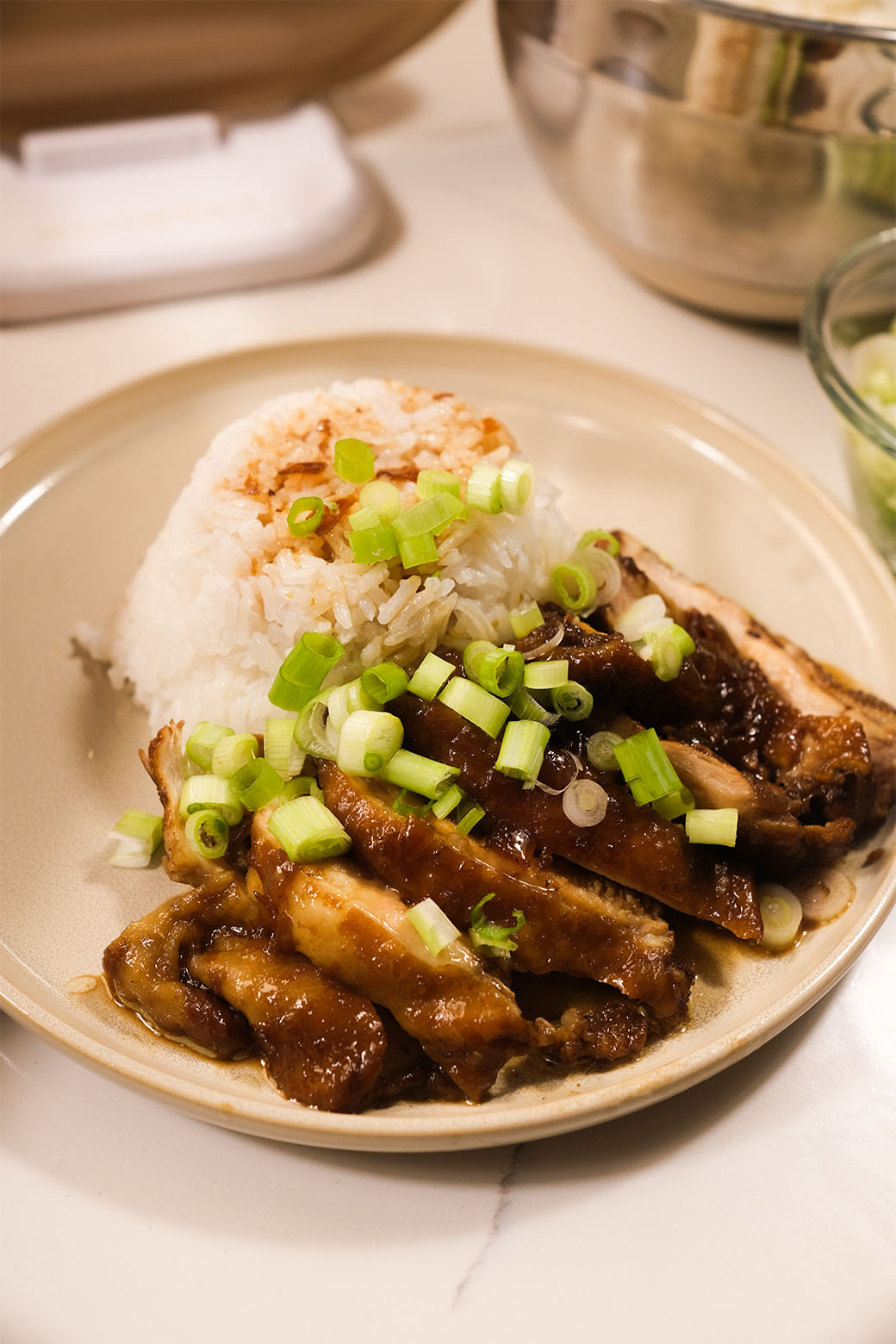 Filipino Chicken Adobo in Claypot Cooker with tender chicken, rich glaze, and fresh scallion garnish.