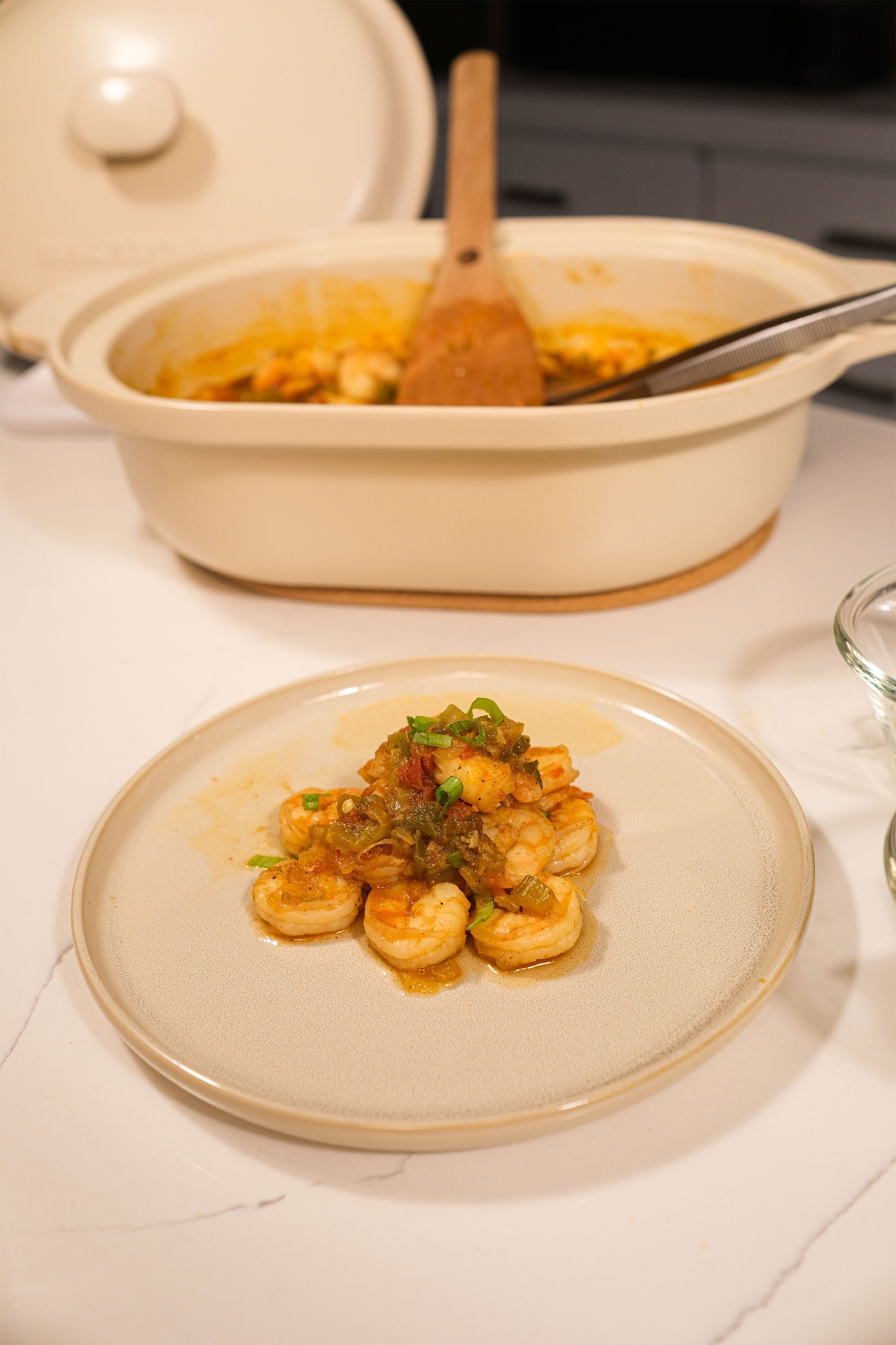 Shrimp Creole served in a Kaolin Claypot—juicy shrimp simmered in a rich, spicy tomato Creole sauce with onions, bell peppers, and celery, garnished with scallions.