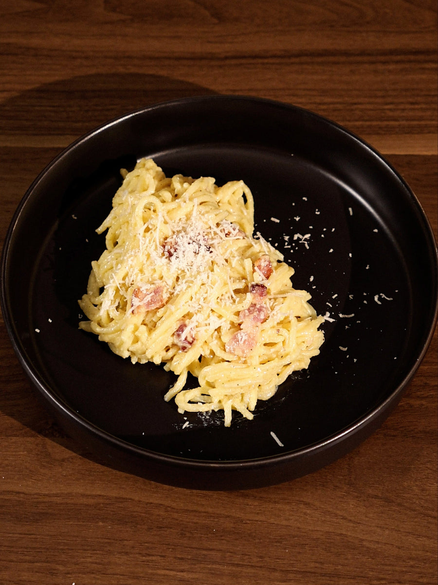 A plate of 20 min made Pasta Carbonara with Pecorino Romano sprinkled on top. Made using the Claypot Multi-Cooker.