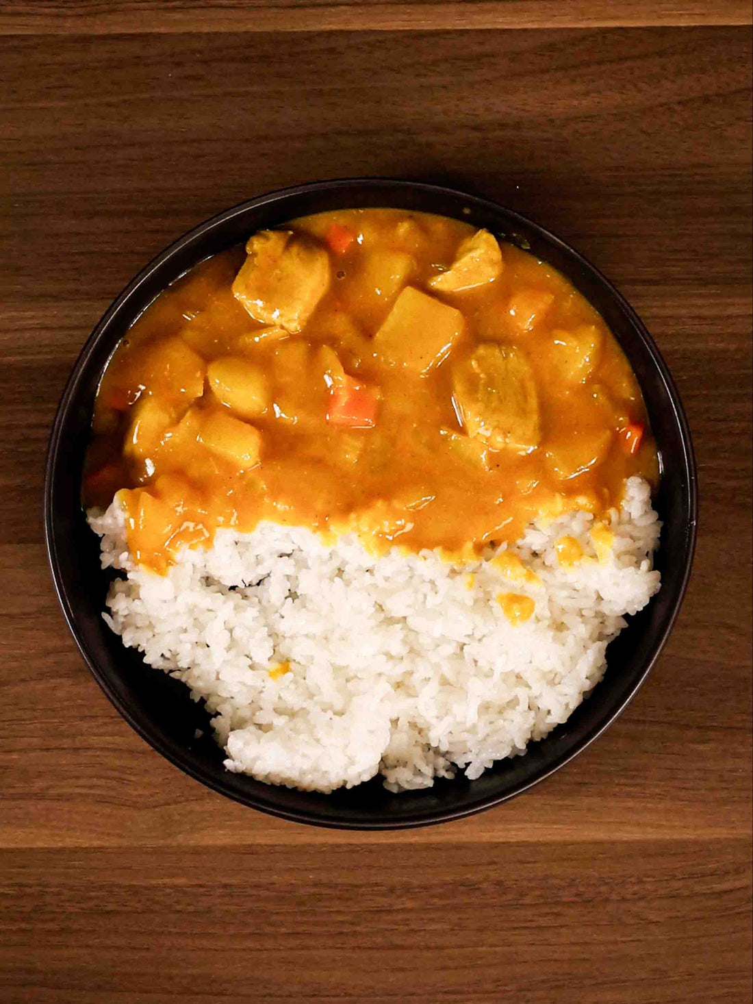 A plate of vibrant and delicious Korean Style Curry and Rice on a black plate. Prepared in the Flami Pot. 