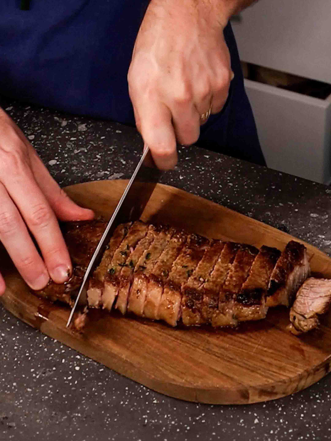 Juicy and delicious Claypot Cooker Garlic Herb Butter Steak sliced on a wooden plate. 