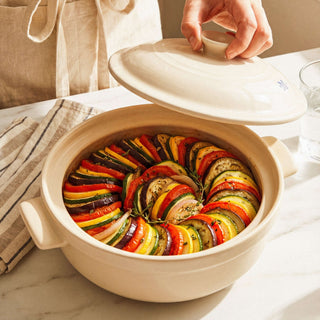 The Flami Pot filled with colorful ratatouille, showcasing its non-toxic clay cookware design.