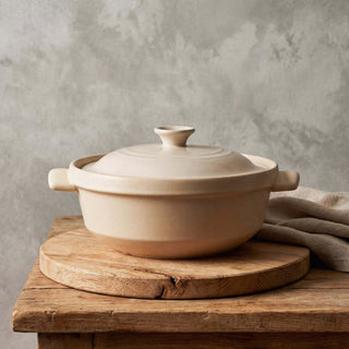The Flami Pot - handcrafted non-toxic clay cookware on a wooden table.