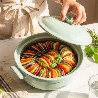 The Flami Pot showcasing a colorful vegetable dish, highlighting its handcrafted non-toxic clay design.