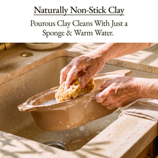 Person cleaning a Casserole Claypot Multi-Cooker with a sponge and warm water in a sink.