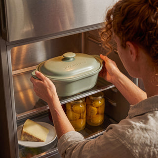 Woman placing the Sage Claypot pot with its lid into a refrigerator for food storage